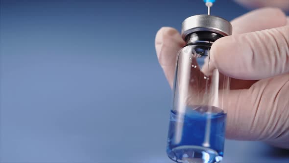 Close Up Mixing of Medicine. Doctor Using Syringe To Squirt Fluid Into Ampoule