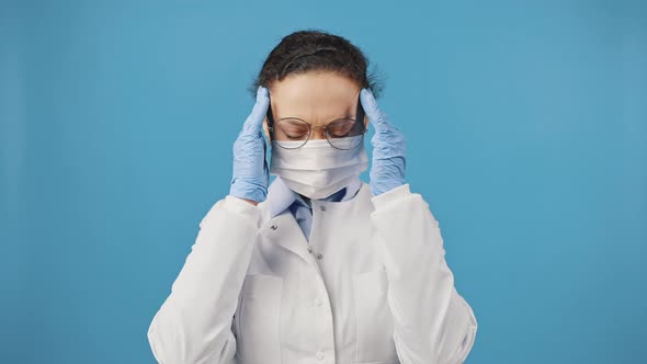 Woman Doctor in Protective Medical Mask Suffering From Headache Massaging Her Temples Feeling Tired