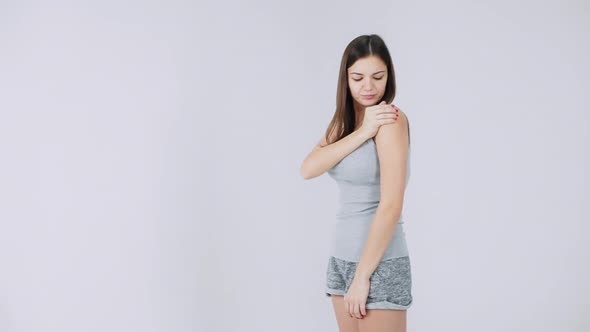 Young Woman Has Pain in the Shoulder, Pain in the Joints, Isolated on a White Background