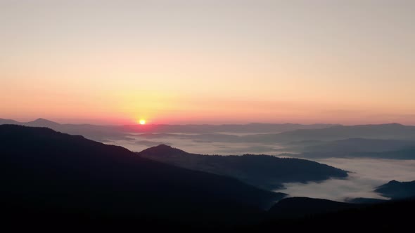 Aerial Drone View, Sunrise or Sunset in the Mountains, Flying Over the Trees in the Sun 