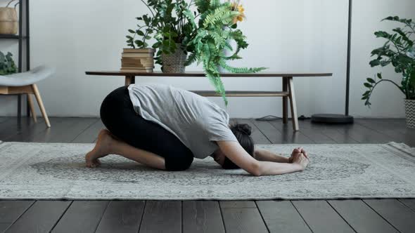 A Young Asian Woman Sits On The Floor Doing A Prayer, Is At Home and Prays in A Cozy Room