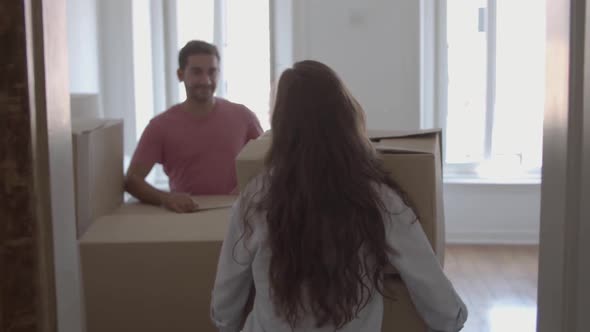 Pretty Woman Coming Into Room, Carrying Box with Different Stuff