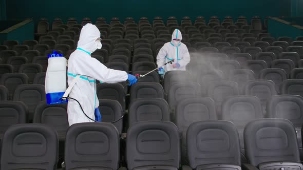 Men Using Equipment for Spraying Antiseptic at Cinema