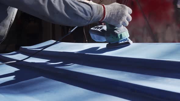  Hand of a Man with a Grinder Who Repairs a Blue Boat