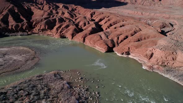 Aerial view of red eroded terrain next to the Colorado River