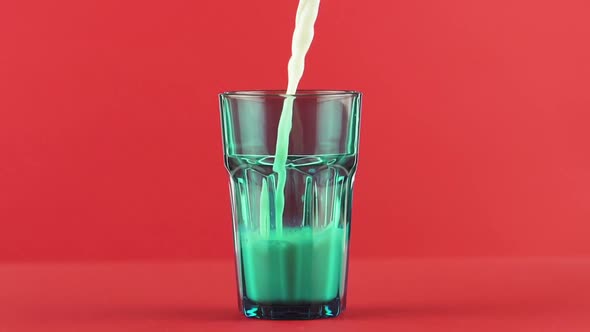 Slow Motion Close-up Shot of Cold Diary Milk Cold Beverage Drink Pooring Into Blue Faceted Glass