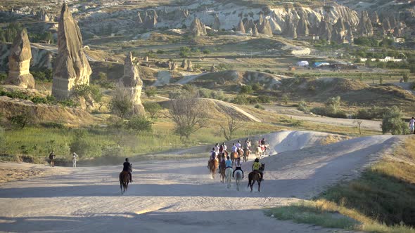 Tourists Who Make Touristic Trips and Walks With Horses Among Hoodoo Fairy Chimneys in Cappadocia