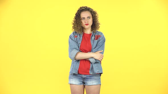 Girl Is Upset, Waving Her Hands in Indignation, Shrugs on Yellow Background at Studio