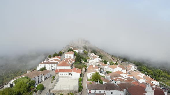 A drone flies over the orange tile roofs of a Portugal village and into the remains of Marvão Castle