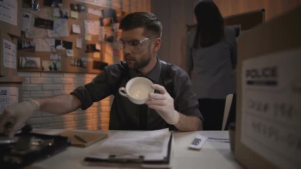 Research Specialist Taking Fingerprints From White Coffee Cup on the Table