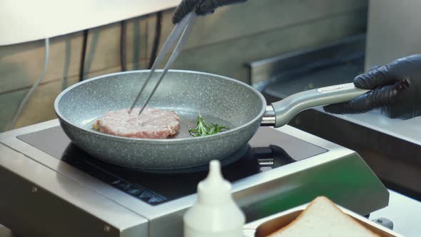 Man in Gloves Putting Raw Burger Meat on Heated Pan