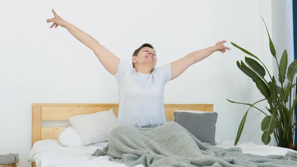 Senior Woman Wakes Up in the Morning in a Light Room