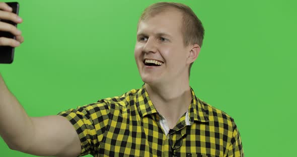 Caucasian Young Man in Yellow Shirt Taking Nice Selfies on the Smartphone