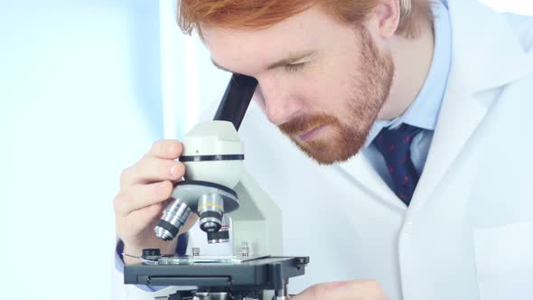 Doctor using Microscope in Laboratory alt