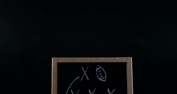 Close-up of American football and game strategy drawn on board