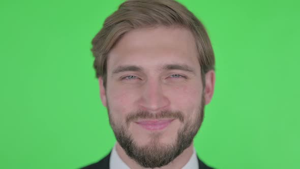 Close Up of Smiling Young Businessman on Green Background