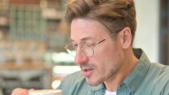 Portrait of Middle Aged Man Drinking Coffee in Cafe