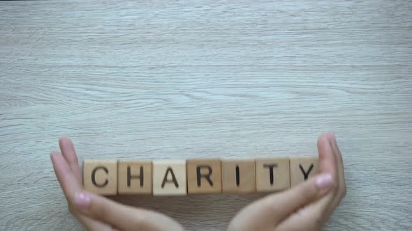 Charity, Hands Pushing Word on Wooden Cubes, Donations and Helping in Need