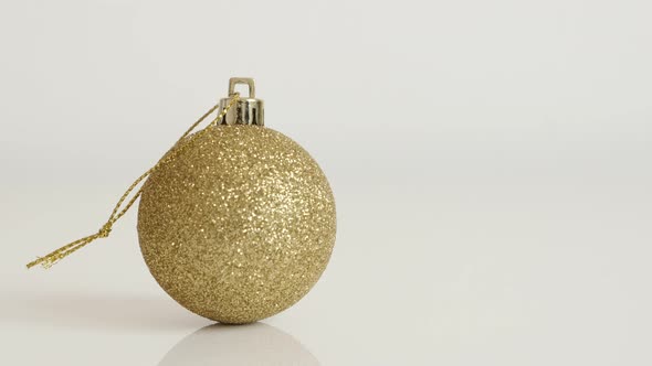 Golden Christmas ornament on white background close-up 4K 2160p 30fps UltraHD tilting  footage - Shi