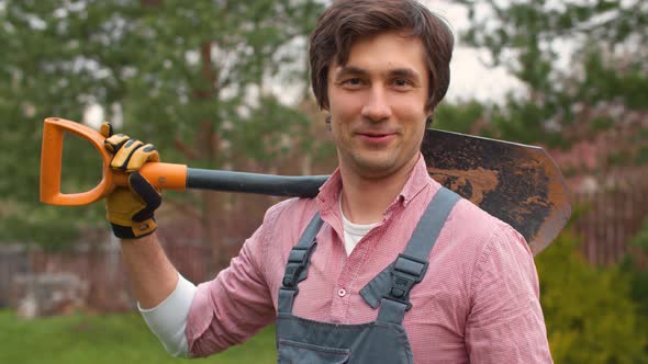 Portrait of a gardener with a shovel on his shoulder