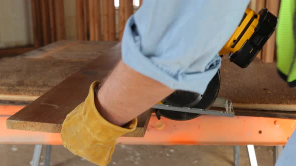 Closeup of construction worker cutting plywood alt