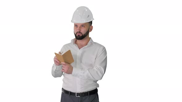 Confident Mature Man in Formalwear and Hardhat Writing Down Notes on White Background