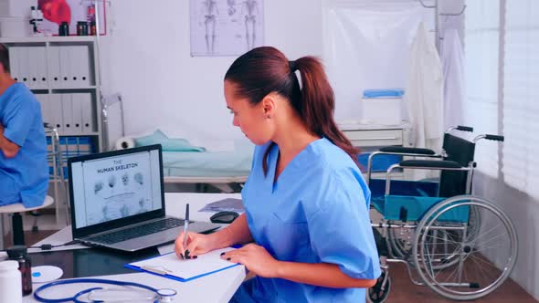 Group of Nurses Working in Hospital Office Analysing Digital Human Skeleton