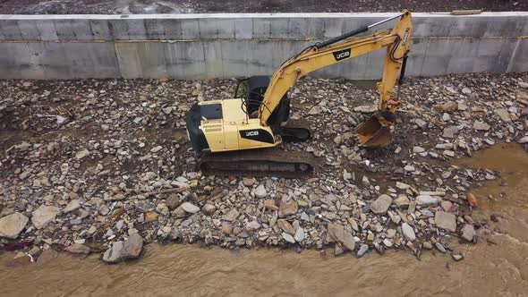 Yellow dredge Excavator working in the mountain river, scooping excavator bucket. Extracting gravel