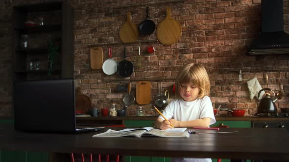 Little Boy Writing Letters in School Notebook