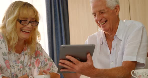 Happy senior couple looking at digital tablet