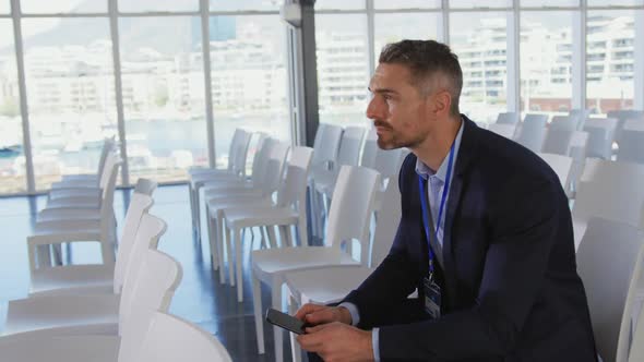 Businessman using smartphone at a seminar