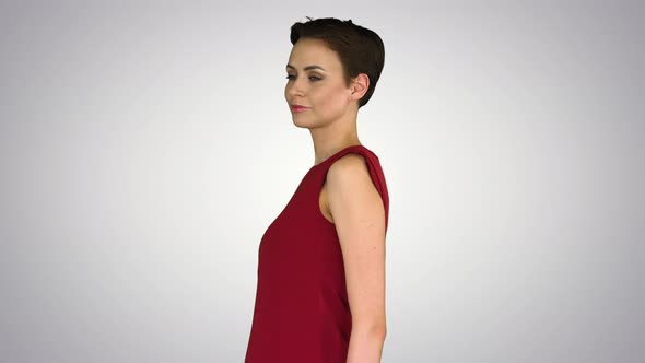 Girl Trying Red Dress Turning Around Like Looking in Mirror on Gradient Background