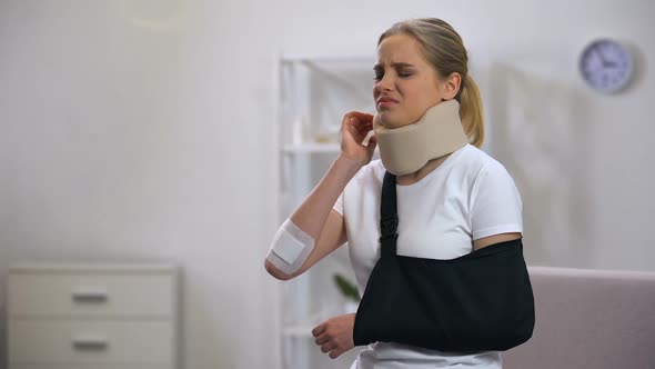 Injured Woman in Foam Cervical Collar and Arm Sling Suffering Pain in Neck Rehab