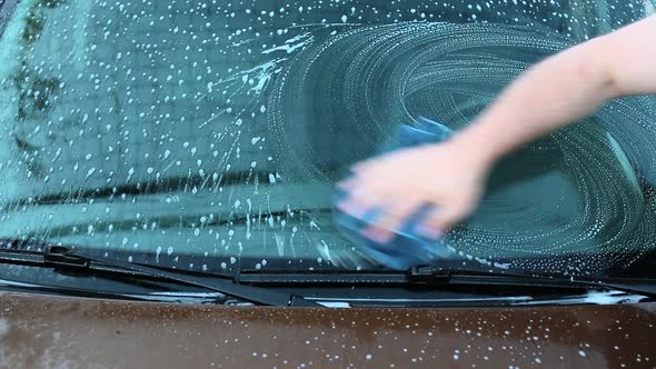 Close Up View of a Man Carefully Wash His Favourite Car Windscreen.
