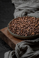 Roasted coffee beans in a plate on a wooden stand. - PhotoDune Item for Sale