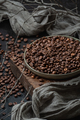 Coffee beans in a plate on a wooden stand. Low key photography c - PhotoDune Item for Sale