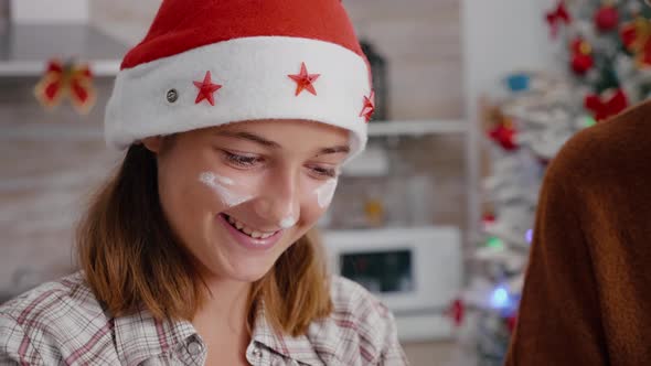 Portrait of Granddaughter with Flour on Face Wearing Santa Hat Cooking Delicious Dessert