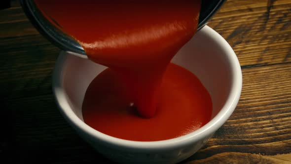 Pot Of Soup Poured Into Bowl On Table