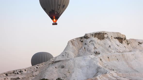 Hot Air Balloons in White Travertines of Pamukkale, a Touristic Natural World Heritage Site