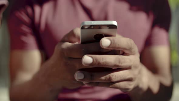 Closeup Shot of Male Hands Typing Message on Smartphone.