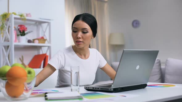 Young Woman Working on Laptop at Home, Freelance Design Project, Self-Employment