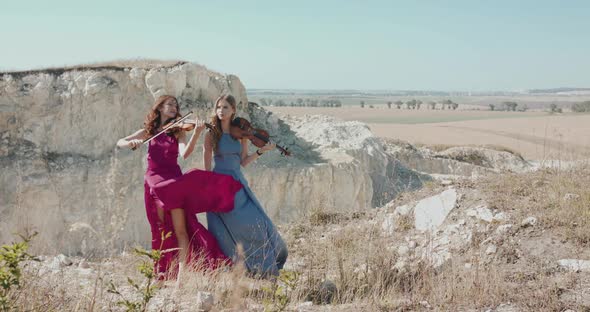 Virtuoso Female Violinists Duet Plays the Music Among the Picturesque Cliffs