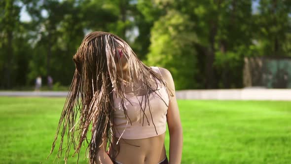 Young Beautiful Girl with Dreads Dancing in a Park