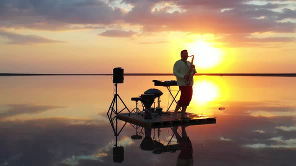 Colorful Sunset in the Background of a Saxophonist Playing in the Sea, 