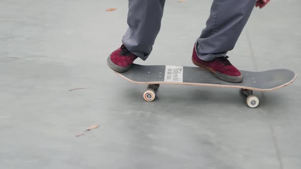 Skater Practicing in the Autumn Concrete Skate Park Making Tricks and Rides in Ramp