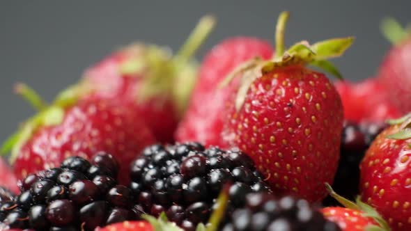 Different Berries in Sugar Spin on a Black Background  Blackberries Raspberries and Strawberries