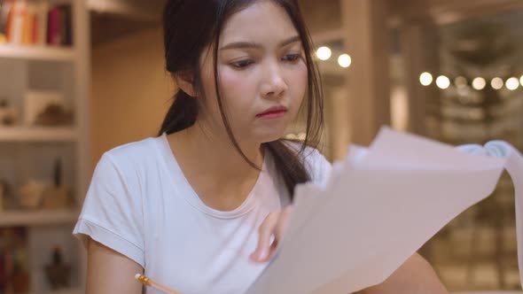 Young undergraduate girl do homework, read textbook, study hard for knowledge on lecture desk