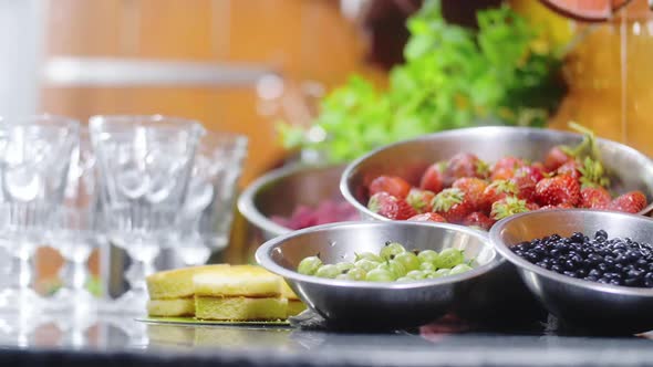 Bowls with fresh fruits: blueberries, gooseberries, strawberries, raspberries.