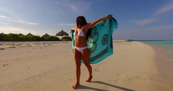 Young fun woman relaxing having fun on the beach on paradise white sand and blue 4K background