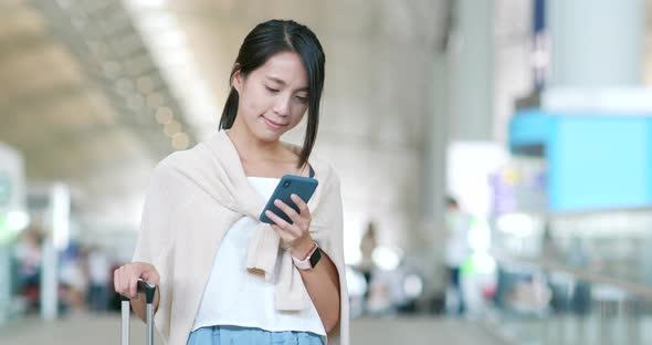 Woman checking on cellphone in the airport